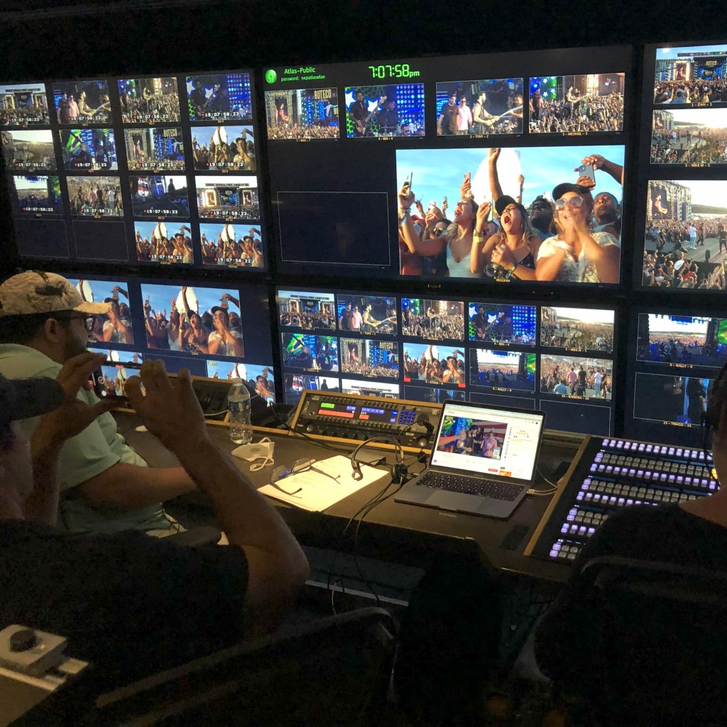 A man directing a live show with lots of monitors in front of him.