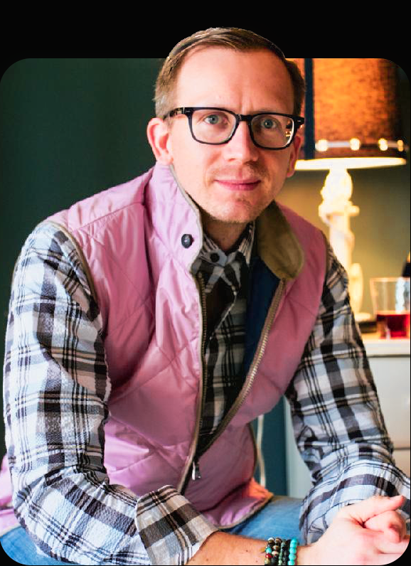 Andrew Oman profile picture. Wearing a pink vest in power glasses.